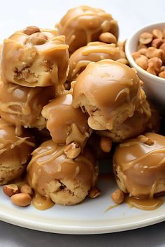 a plate full of peanut butter pretzels next to a small bowl of peanuts