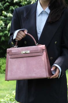 Rare doesn't even come close to describing this bag. A one-of-a-kind 32cm Sellier Kelly, this special order piece goes beyond what many believe possible from Hermès. Crafted in 2012 at the special request of a top-tier client, this bag features a soft pink body done in Rose Indienne Doblis Suede, framed by glossy Mauve Lizard forming the edges, handle, straps and clochette. Paired with Palladium hardware the effect is stunning, soft and full of color all at once, clearly and undeniably a standou Hermes Wishlist, Pink Kelly, Kelly 32, Investment Bags, Hermes Kelly Bag, Luxury Marketing, Pink Body, Handbag Organization, Kelly Bag