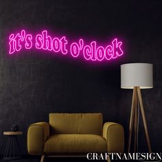 a neon sign that says it's shot o'clock on the wall next to a couch