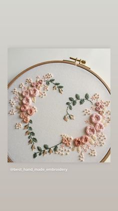 an embroidery project with pink flowers and green leaves