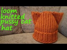 an orange knitted cat hat sitting on top of a couch