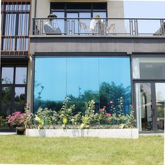 two people sitting on the balcony of a building with flowers and plants in front of them