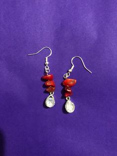 Red coral gem earrings, made with silver plated hooks and cubic zirconia charms. Silver Dangle Earrings With Stones, Sterling Silver Dangle Earrings With Stones, Sterling Silver Drop Earrings With Stones, Sterling Silver Stone Drop Earrings, Red Crystal Dangle Jewelry, Red Crystal Drop Earrings, Red Crystal Dangle Earrings, Red Crystal Earrings For Gift, Red Gemstone Cluster Earrings For Gift