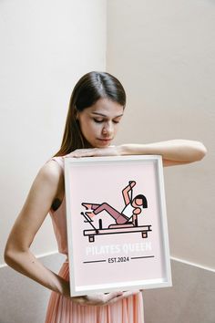 a woman holding up a poster with a man doing pilates queen on it