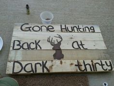 a wooden sign that says gone hunting back at dark thirty and is sitting on the ground