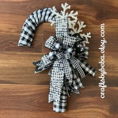 a black and white christmas wreath with snowflakes on it sitting on a wooden floor