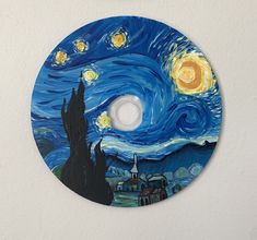 a painting on a white wall with a blue and yellow circle painted in the shape of a starry night