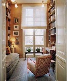 a living room filled with lots of furniture and bookshelves next to a window