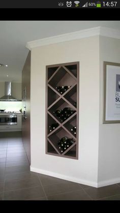 a wine rack in the corner of a room with tile flooring and white walls