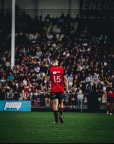 a soccer player is standing on the field in front of an arena full of people