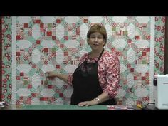 a woman standing in front of a quilt