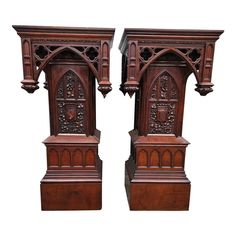 pair of carved wooden bookends on pedestals in the style of gothic architecture