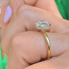 a close up of a person's hand holding a ring with a diamond on it