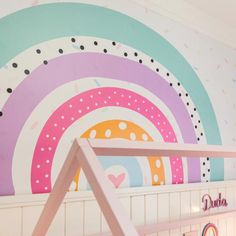 a child's room with a rainbow painted on the wall