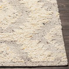 a white rug on top of a wooden floor