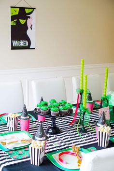 the table is set with cupcakes, candy cups and napkins on it