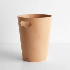 a wooden cup with a hole in the middle on a white surface, ready to be used as a planter