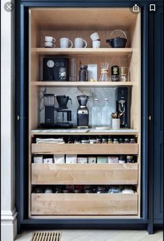 an open cabinet filled with lots of coffee and tea cups on top of wooden shelves