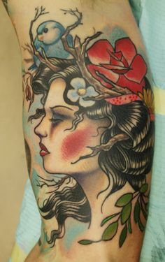 a woman with flowers and birds on her head is shown in this tattoo art piece