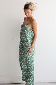 You'll bring an undeniable energy to any room in the Bright Perspective Green Floral Wide Leg Jumpsuit! This women’s jumpsuit features a lush green hue adorned with a beautiful floral print, creating a lively and sophisticated look that’s perfect for any occasion. Crafted from a lightweight, breathable fabric, the "Verdant Bloom" jumpsuit drapes gracefully, offering both comfort and style. Ideal for everything from garden parties to casual evening events, this jumpsuit pairs effortlessly with bo Green Floral Print Jumpsuit For Vacation, Casual Green Floral Print Jumpsuit, Green Printed Summer Jumpsuit, Casual Green Floral Print V-neck Dress, Green V-neck Tropical Print Jumpsuit, Trendy Jumpsuit, Minimal Accessories, Casual Evening, Garden Parties