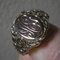 Such a beautiful ring for they guys but could be sized down for the ladies, within reason. This ring has fabulous scroll detailing on the shoulders. The oval face area is approx. 5/8 inches long and under 1/2 inch wide. Marks are the back 10 k and tested as such. Ring is heavy at 8.8 grams and approx. a size 13. This ring has been size up in the past. You can feel a slight ripple in the band in back as well as it being a bit thinner. Not an issue but an observation. The initials on the face look 14k Gold Engraved Ring With Initials For Collectors, Ornate 14k Gold Collectible Ring, Oval Engraved Signet Ring For Collectors, Luxury Oval Signet Ring With Intricate Design, Silver Heirloom Initial Ring For Wedding, Victorian Oval Engraved White Gold Ring, Antique Signet Ring With Initials For Formal Events, Victorian Rings With Engraving Option For Anniversary, Victorian Signet Ring With Intricate Design