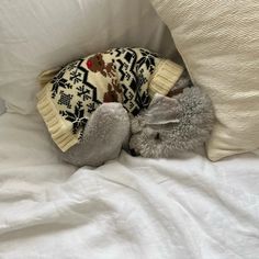 a stuffed animal laying on top of a white bed