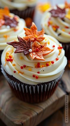 cupcakes decorated with white frosting and fall leaves