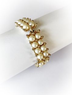 "Pretty vintage faux pearl link bracelet! 5 links with 8 pearls on each link in 2 rows. Has a flip style latch. Overall good/fair condition. Metal is free of rust and verdigris. There is minor to moderate wear to the gold tone finish. Minor wear to the \"pearls\". No makers mark. End to end measures 7 and 3/8 inches and 5/8 of an inch wide. Discounts offered for bulk purchases. Shop accepts PayPal, credit cards, Etsy gift cards, and postal money orders. ♥Check out the rest of the shop♥ https://w Classic Metal Pearl Bracelet For Formal Occasions, Vintage Gold Pearl Bracelet For Formal Occasions, Vintage Pearl Bracelet For Formal Occasions, Vintage Pearl Beaded Bracelet, Vintage Gold Pearl Bracelets, Vintage Gold Pearl Bracelet Gift, Vintage Metal Pearl Bracelet For Formal Occasions, Vintage Gold Pearl Bracelet, Vintage Gold Beaded Jubilee Bracelet