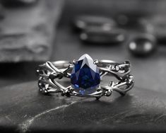 Pear Cut Royal blue sapphire bridal set with solid black gold setting, the setting goes with unique black diamond or black moissanite accent which match perfectly the black gold shank, if you prefer to have black setting engagement ring set, this might be the one. Rhodium black engagement ring like no other. This AMAZING piece of fine jewelry is the perfect expression of your eternal love. Its BLACK colors bring out the beauty of this ring. ★Description Main ring: *Center stone: 1.7 Carat 8x6mm Black Diamond Bridal Set, Sapphire Bridal Set, Dark Blue Wedding, 6mm Wedding Band, Gothic Engagement Ring, Sapphire Engagement Ring Set, Blue Sapphire Engagement Ring, Black Gold Ring, Promise Ring Set