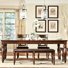 a dining room table and chairs with pictures on the wall above it, along with a bench