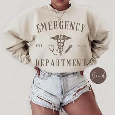 This unisex Gildan sweatshirt features a bold graphic of Asclepius with "Emergency Department" text, perfect for ER staff, health workers, and doctors. A thoughtful gift for anyone in emergency care, you can personalize the year to mark when the journey began--whether it's the start of a career or graduation. .: 50% cotton, 50% polyester  .: Medium-heavy fabric (8.0 oz/yd² (271.25 g/m .: Loose fit  .: Sewn-in label  .: Runs true to size For the oversized look, we recommend going up one or two sizes from your regular fit for a relaxed and roomy feel. To ensure the longevity and vibrant appearance of your item, please follow these care instructions: - Turn garment inside out for washing and drying - Machine wash cold only (on delicate cycle and use mild detergent) - Tumble dry on low heat se Er Tech, Nurse Sweater, Washing And Drying Machine, Health Workers, Emergency Care, Drying Machine, Er Nurse, Nurse Sweatshirt, Emergency Department