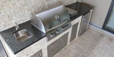 an outdoor kitchen with stainless steel appliances and granite counter tops