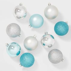 blue and white ornaments are arranged on a white surface