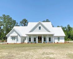 a large white house sitting on top of a lush green field