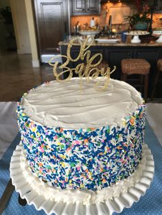 a cake that is sitting on top of a blue and white table cloth with the word eat spelled in gold