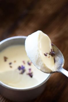 a spoon full of ice cream with flowers on it's side and some sugar in the middle