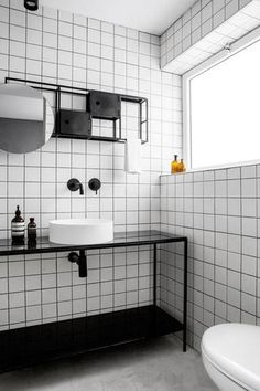 a bathroom with black and white tiles on the walls