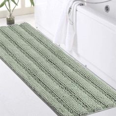 a bath mat sitting next to a toilet in a bathroom