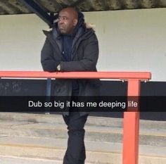 a man standing next to a red bench with the words dub so big it has me deeping life