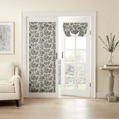 a living room with white furniture and curtains