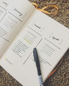 an open planner with a pen on top of it