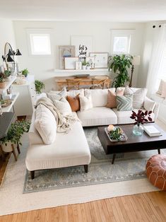 a living room filled with lots of furniture and plants on top of the couches