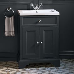 a bathroom sink sitting under a mirror next to a towel dispenser on a wall