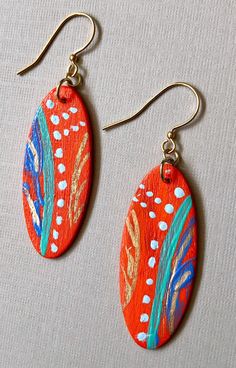 two pairs of earrings with painted designs on them