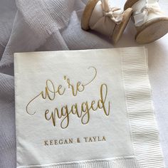 there is a napkin with the words we're engaged on it next to shoes