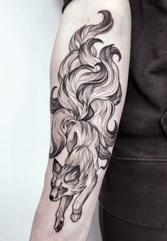 a woman's arm with a wolf tattoo on it