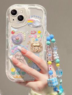 a woman holding up her phone case with charms on it