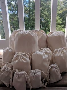 a stack of six bags sitting on top of a wooden table next to a window