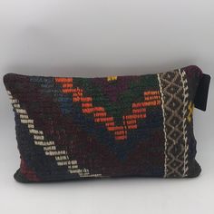 a decorative pillow with an unusual design on it's side and a tag hanging from the front