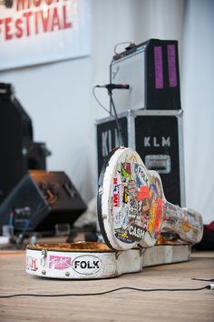 an old broken up speaker sitting on top of a wooden table next to other musical equipment